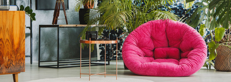 Pinker Sessel umgeben von Pflanzen